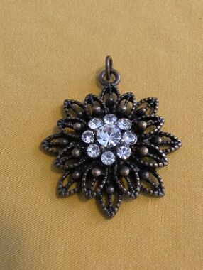 Vintage filigree designed pendant in a stylized flower or starburst shape